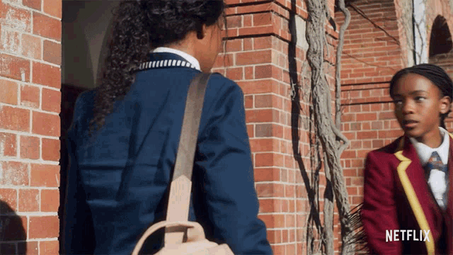 two girls are standing in front of a brick building with a netflix logo in the corner