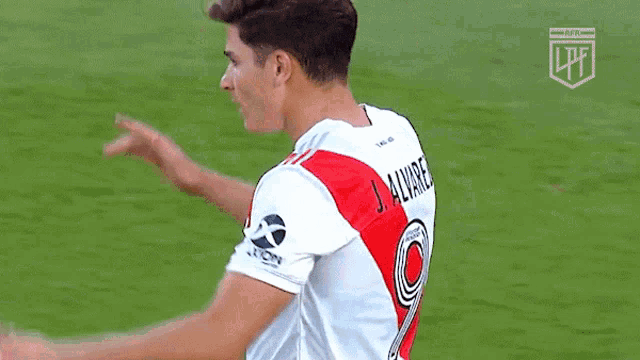 a soccer player wearing a red and white jersey with the number 9 on it