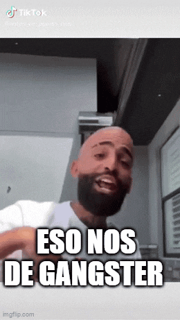 a man with a beard is making a funny face and says " eso nos de gangster "