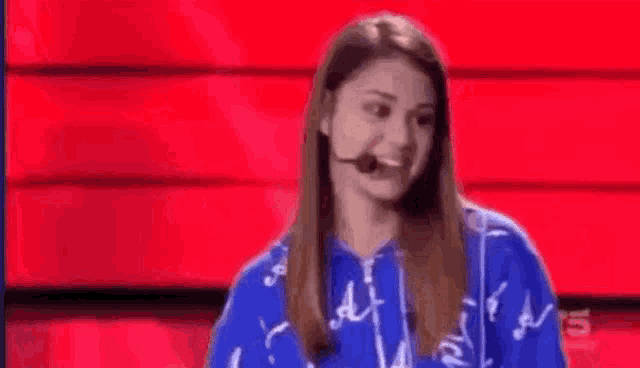 a woman is standing in front of a microphone on a stage .