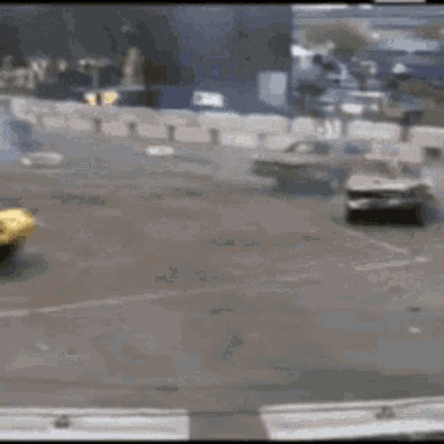 a blurred image of a race track with a yellow buggy in the foreground