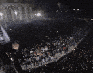 a crowd of people are gathered in front of a building that says zdf on the bottom