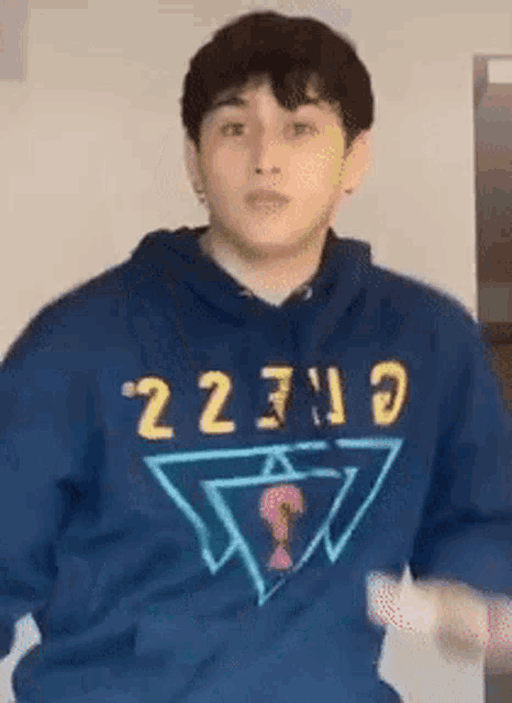 a young man wearing a blue hoodie with the word guess on it is dancing .