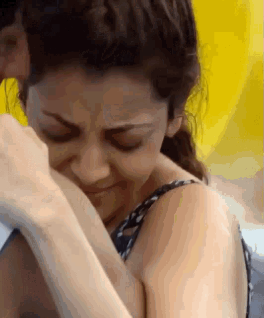 a woman is crying and covering her face with her hand .