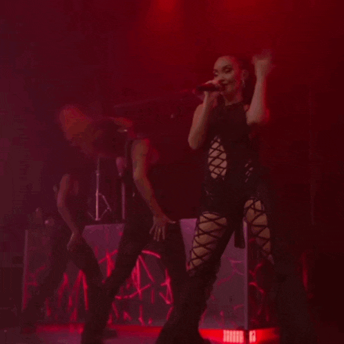 a woman singing into a microphone on stage