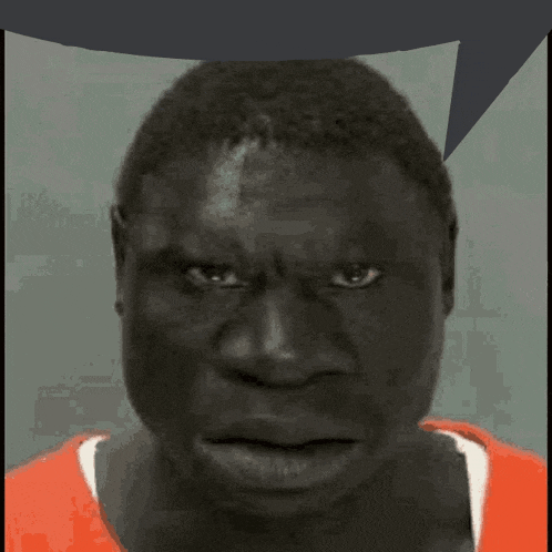 a close up of a man 's face in an orange shirt
