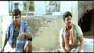 two men are sitting in front of a wall that says ' chennai '