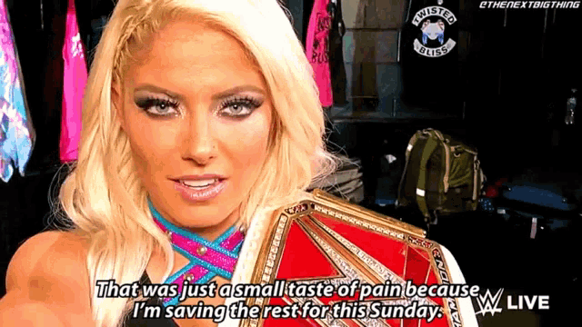 a woman is holding a wrestling belt and says that was just a small taste of pain because i 'm saving the rest