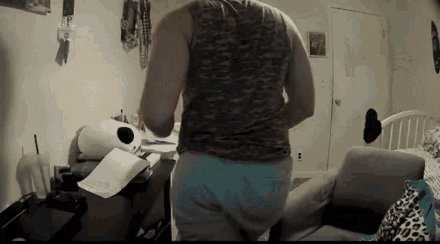 a person standing in a room with a couch and a desk