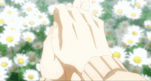 a person holding a small bird in their hands with flowers in the background