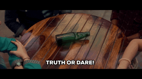 a group of people sitting around a wooden table with the words truth or dare below them