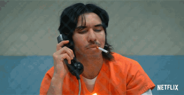 a man lighting a cigarette while talking on a phone with netflix written on the bottom