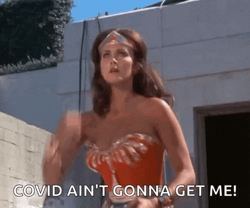 a woman in a wonder woman costume says covid ain 't gonna get me .