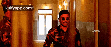a man in a military uniform is standing in a hallway .
