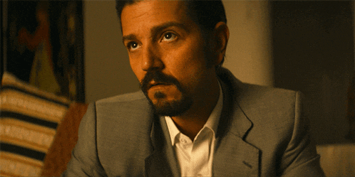 a man with a beard is wearing a suit and a white shirt