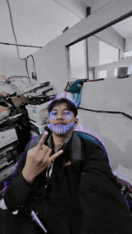 a man with a mask on his face giving the middle finger in an office