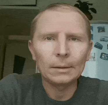 a man 's face is shown in front of a refrigerator with pictures on it