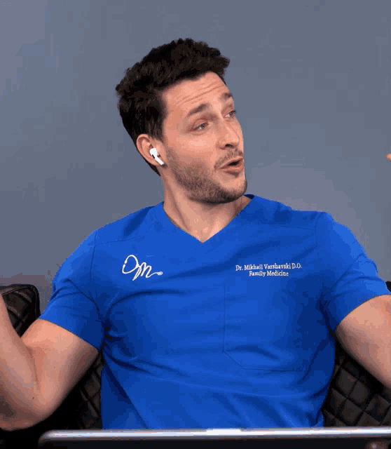a man wearing a blue shirt that says dr. michael hasharski d.d. family medicine