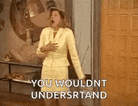 a woman in a yellow suit is standing in front of a door and saying `` you wouldn t understand '' .
