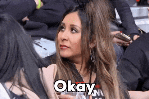 a woman sitting in a crowd with the word okay written on her face