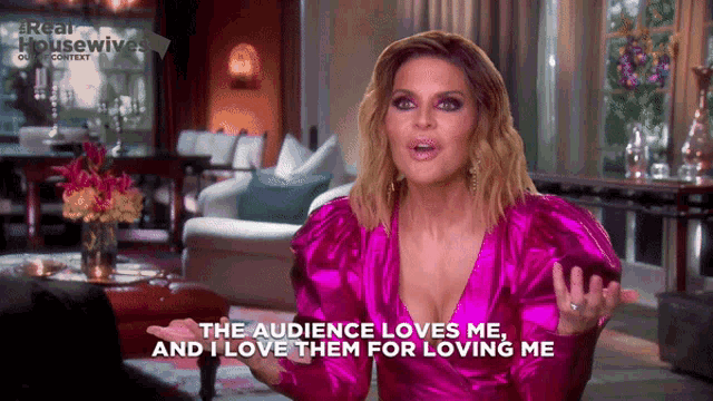 a woman in a pink dress says " the audience loves me "