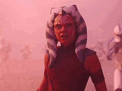 ahsoka tano from star wars : the clone wars is standing in front of a group of stormtroopers in a pink fog .