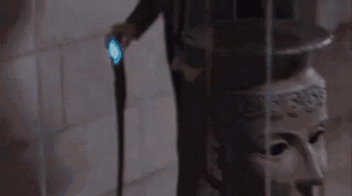 a man in a suit and tie is walking in a dark room .