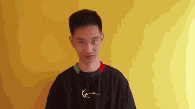 a young man wearing a black shirt with karl kani on it