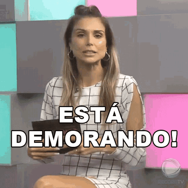 a woman sitting in front of a sign that says está demorando