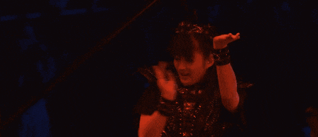 a woman with her arms outstretched is wearing a black top