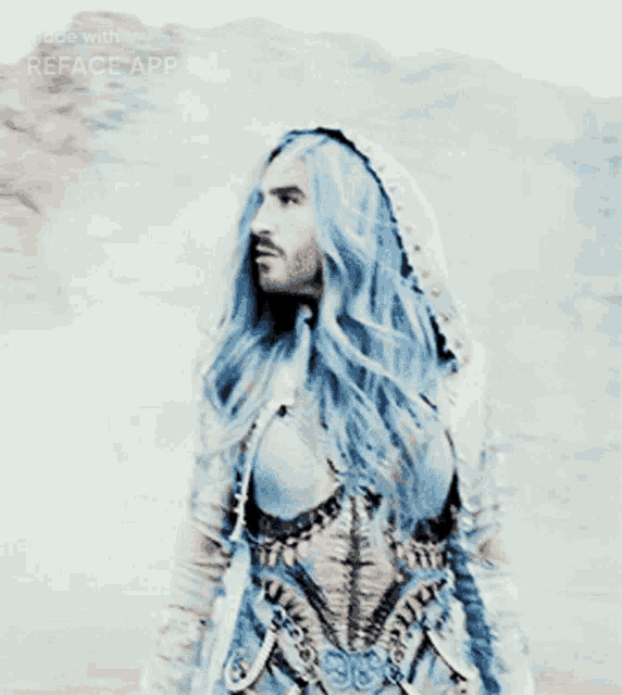 a man with long blue hair is wearing a hooded top