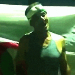 a man with a bandage on his head stands in front of a green background