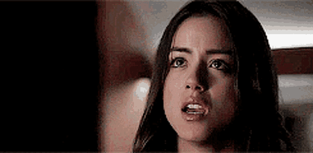 a close up of a woman 's face with a surprised expression on her face .