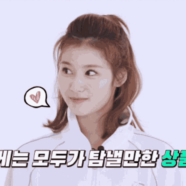 a woman is smiling with a heart in a speech bubble above her head with korean writing