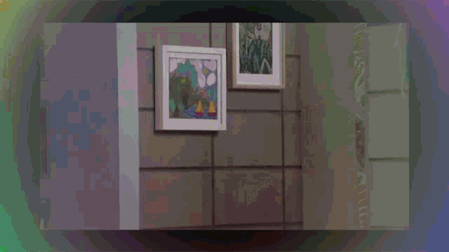 a woman is dancing in front of a framed picture on the wall