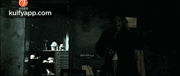 a man is standing next to a car in a dark room .