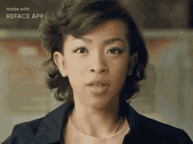 a woman with short hair is wearing a black jacket and a pink shirt and looking at the camera .
