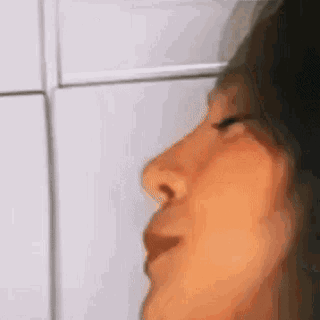 a close up of a woman 's face with her eyes closed and her mouth open .