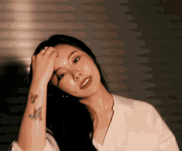 a woman with a tattoo on her wrist with the letter m