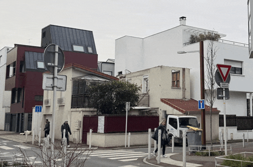 a white truck is parked in front of a building that has a sign that says " zone de circulation "