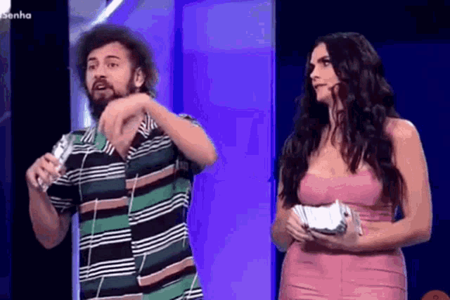 a man with a beard and a woman in a pink dress are standing next to each other