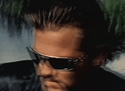 a close up of a man wearing sunglasses and looking at the camera .