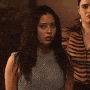 two women are standing next to each other and talking to each other in a dark room .