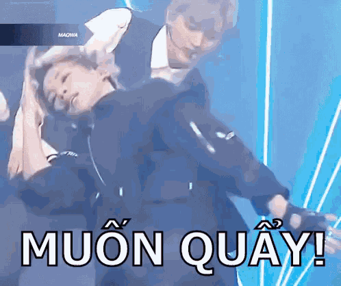 a man and a woman are dancing on a stage with the words muon quay written on the bottom .