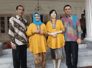 a group of people posing for a picture with one woman wearing a blue head scarf