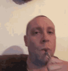 a man is smoking an electronic cigarette in front of a camera .