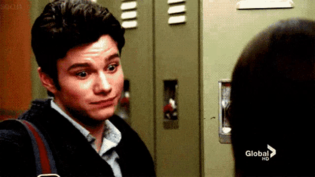 a man is looking at a woman in front of a locker that says global hd