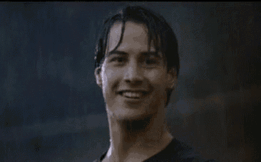a man in a black shirt is giving a thumbs up in the rain .