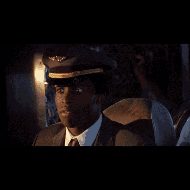 a man in a suit and tie wearing a pilot hat