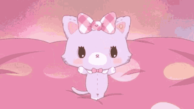 a purple cat with a pink bow on its head is standing on a pink pillow .